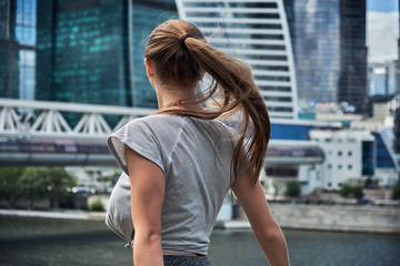 Back view of tourist girl hipster with long hair grows in the wind