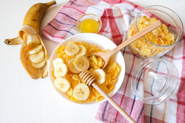 Traditional breakfast cereal of cornflakes and milk with a banana. Healthy lifestyle food.