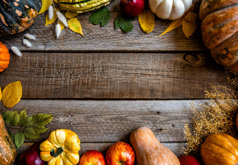 Frame of fall healthy vegetarians food. Cooking background. Ingredients for Thanksgiving day dinner. Corn, pumpkin, fruits over wooden table, top view.