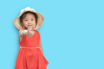 Little girls wearing red shirts and a straw hat on blue background with free space.