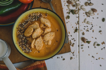Food and drink, still life, diet and nutrition concept. Seasonal fall autumn roasted orange pumpkin carrot soup with ingredients on a table. Copy space cozy background, top view flat lay.