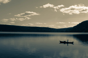 dark artistic picture of Devil's Lake WI , with boat floating on water , long exposure