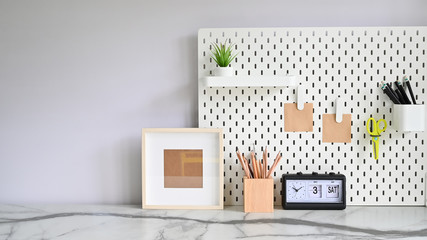 Front view of marble desk and office supply with pegboard.