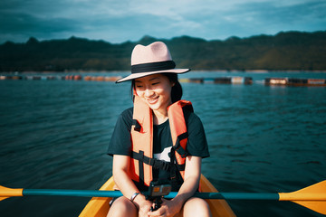 Obraz premium Asian girl is kayaking at Kanchanaburi, Thailand.