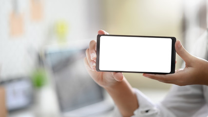 Close-up female's hands showing blank screen of mobile phone.
