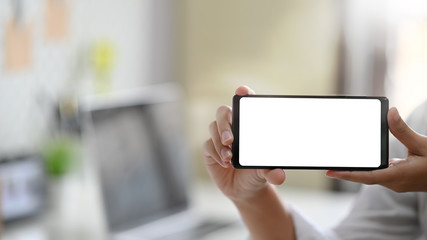 Young woman's hands holding blank screen of smartphone.