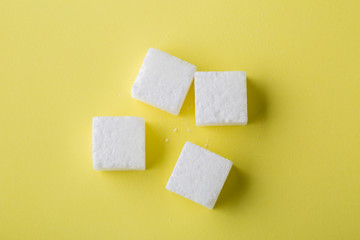 Top view of sugar cube on yellow background. Copy space