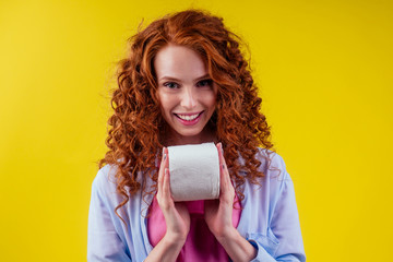 redhaired curls ginger female with hygiene paper on studio yellow background
