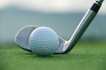 Golf ball and golf club in beautiful golf course at sunset background. Golf ball on green in golf course at Thailand