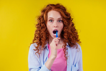 woman redhaired ginger with eco toothbrush and toothpaste on yellow studio background