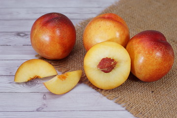 Naklejka na ściany i meble fresh nectarine fruit also as known peach fruit served on burlap background