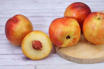 Naklejka na ściany i meble fresh nectarine fruit also as known peach fruit served on wood texture background
