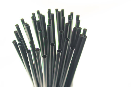 Bundle of black plastic straws, center left