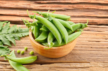 Fresh green peas isolated on a wooden background