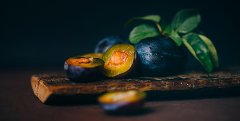 Red cherry plum with green leaves on dark background. Toned image with copy space.