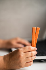 Unhealthy snack at work time. Woman eating cookies and drinking coffee at workplace. High calorie, fattening junk food, weight gain