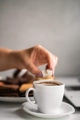 Sugar addiction, unhealthy lifestyle, weight gain, dietary and medical concept. Woman adding sugar cubes into coffee cup