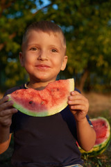 little boy eating watermelon in summer