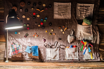 Sewing cloth with scissors, threads and needles in sewing workshop