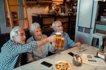 Beaming pensioners watching football match in the pub