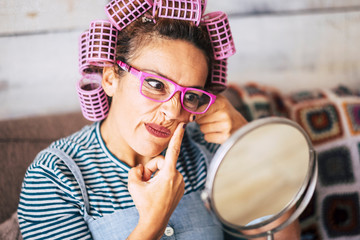 Funny and beautiful young people middle age caucasian woman check for acne or wrinkles on his face...