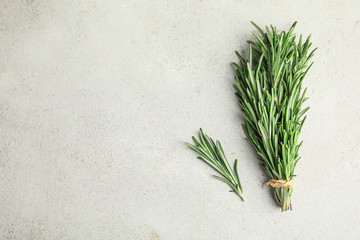Bunch of fresh rosemary on light table, top view with space for text