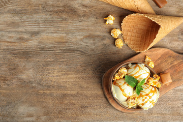 Fototapeta premium Flat lay composition with delicious ice cream on wooden table. Space for text