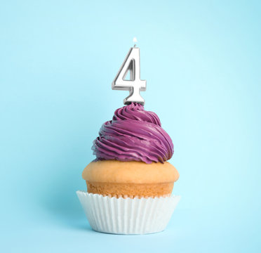 Birthday cupcake with number four candle on blue background