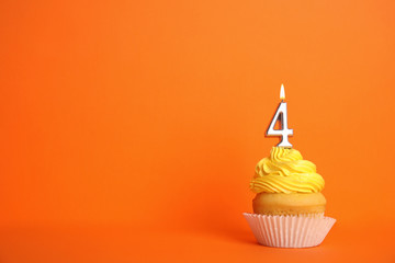 Birthday cupcake with number four candle on orange background, space for text