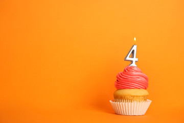Birthday cupcake with number four candle on orange background, space for text