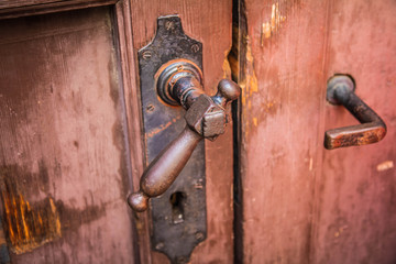 Ancient door handle on old wooden door in close up