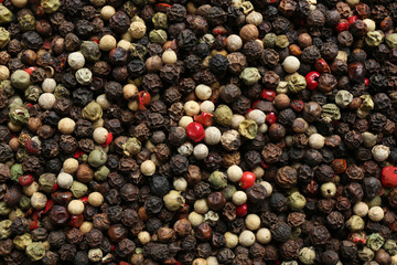 Many different peppercorns as background, top view