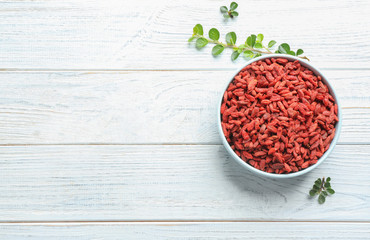 Flat lay composition with dried goji berries on white wooden table. Healthy superfood