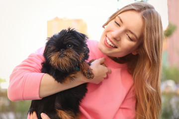 Young woman with adorable Brussels Griffon dog outdoors