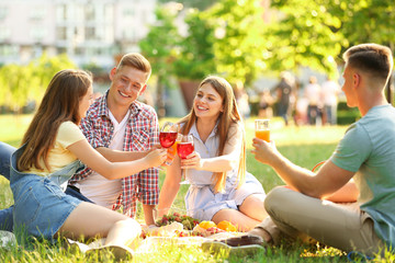 Young people enjoying picnic in park on summer day