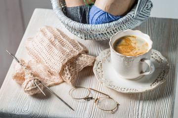 Fototapeta na wymiar Handmade knitted scarf made of colored woolon white table