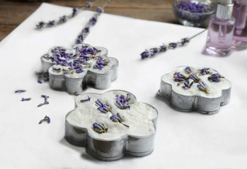 Handmade soap bars with lavender flowers in metal forms on white paper