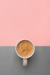 Cup of coffee on color background, top view. Space for text