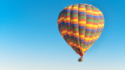 Multi-colored balloon flying in the sky in Cappadocia Turkey