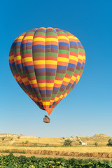 Multi-colored balloon flying in the sky in Cappadocia Turkey