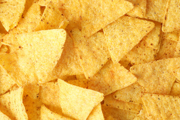 Tasty Mexican nachos chips as background, top view