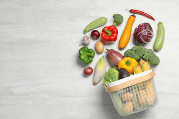 Flat lay composition with different vegetables and basket on light background. Space for text