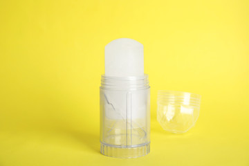 Natural crystal alum stick deodorant and cap on yellow background