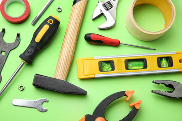Set of repair tools on light green background, flat lay