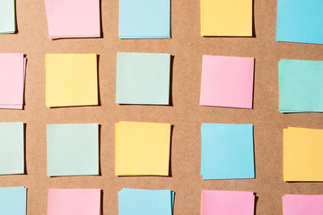 Multi colored notepads laying on a wooden plank board surface with copy space