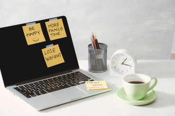 cropped image of woman holding paper sticker with word ideas near laptop