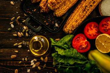 Grilled corn cobs with spice, garlic, lemon, paprika, organic vegetables and cheese. Mexican food. Healthy, organic, homemade food. Toned image. Flat lay with copy space.