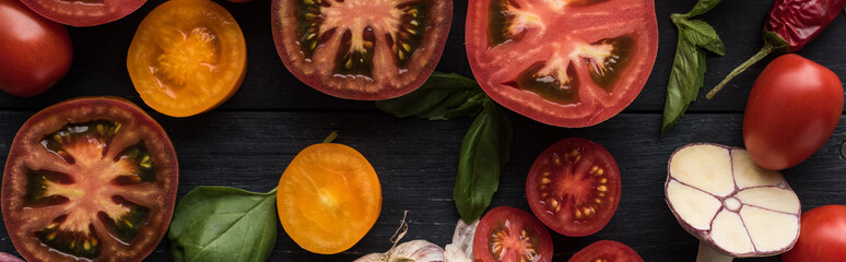 panoramic shot of tomatoes, garlic, spinach, chilli pepper on tray on wooden table