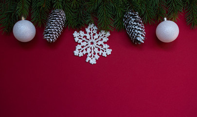 Christmas composition. Fresh fir tree branches, decorations on red background. Christmas, winter, new year concept. Flat lay, top view, copy space.