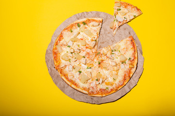 Fresh pizza isolated on yellow background. Flat lay photo.